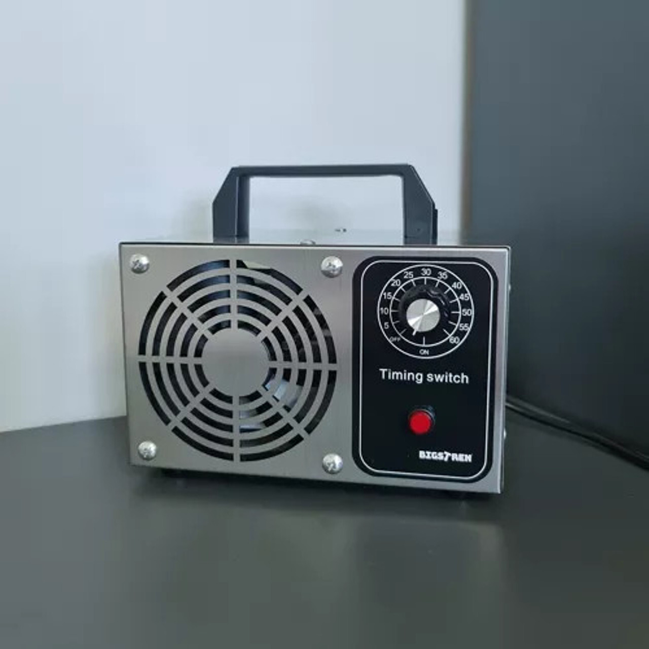 Generator ozona Bigstren 21208 – 20 000 mg/h, prijenosni s tajmerom 1–60 min Prijenosni generator ozona Bigstren 21208 od nehrđajućeg čelika na radnoj površini; ventilator i mehanički tajmer, kapacitet 20 000 mg/h, snaga 50–120 W, ručka za nošenje – za dezodoriranje prostorija i vozila (koristiti u praznim prostorima).