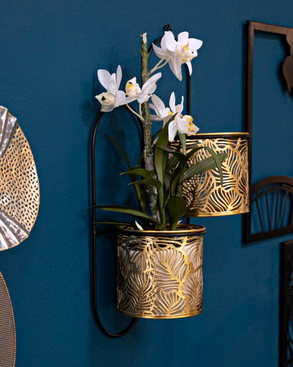 Dekorativni dvostruki zidni nosač za vaze u zlatnoj boji s bijelom orhidejom na tamnoplavom zidu, elegantan zidni stalak za cvijeće za dnevni boravak.